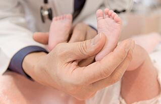插圖 - 醫生托著嬰兒的腳